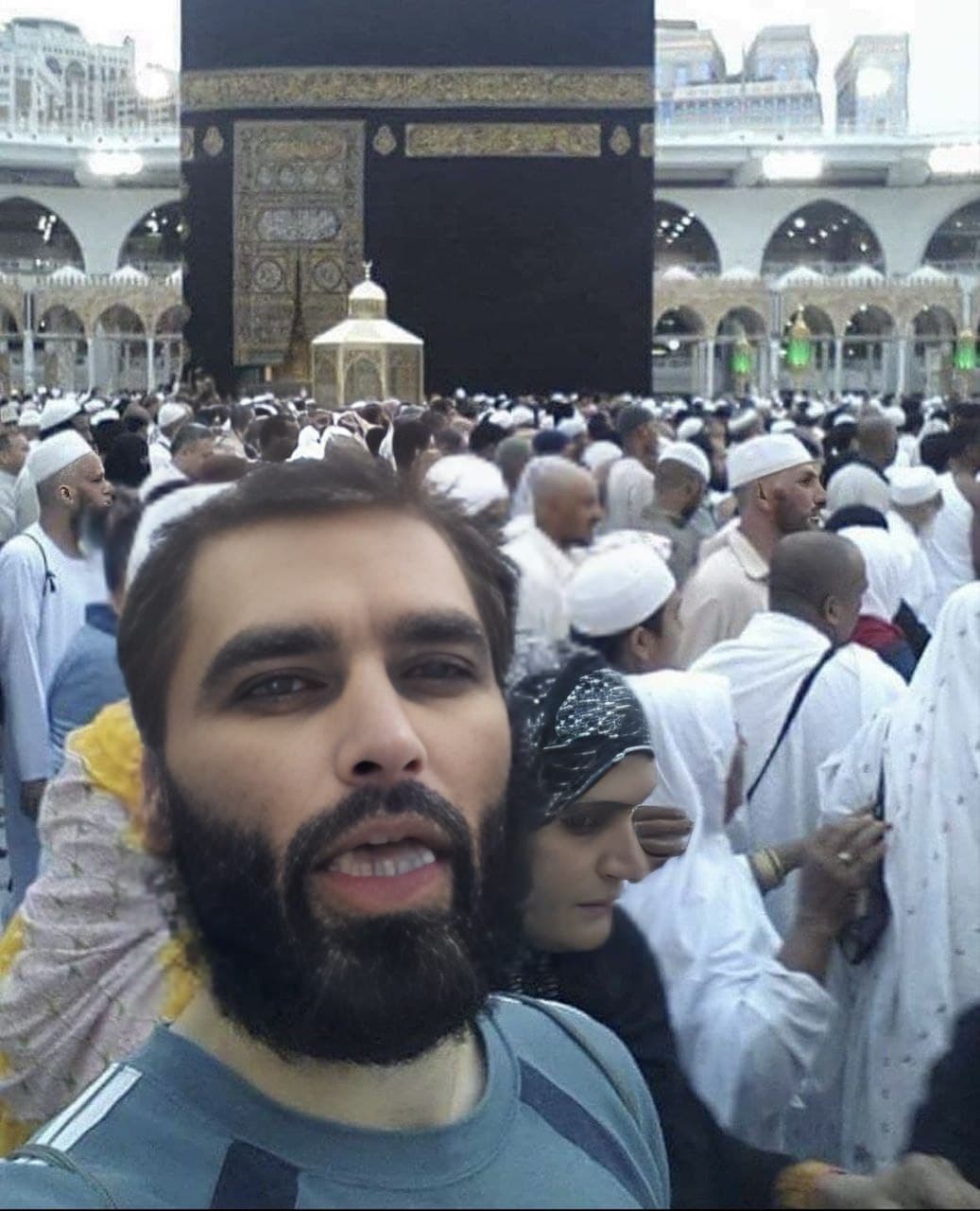 A bearded man with a crowd at the Kaaba.