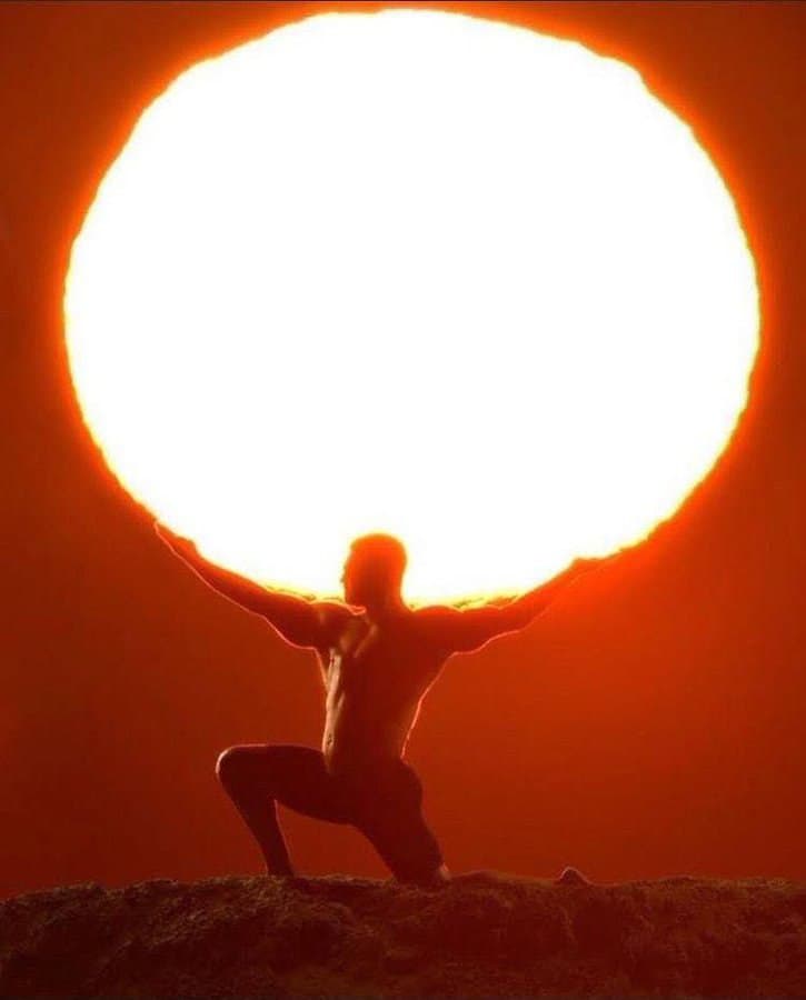 Muscular figure lifting a giant sun in the sky.