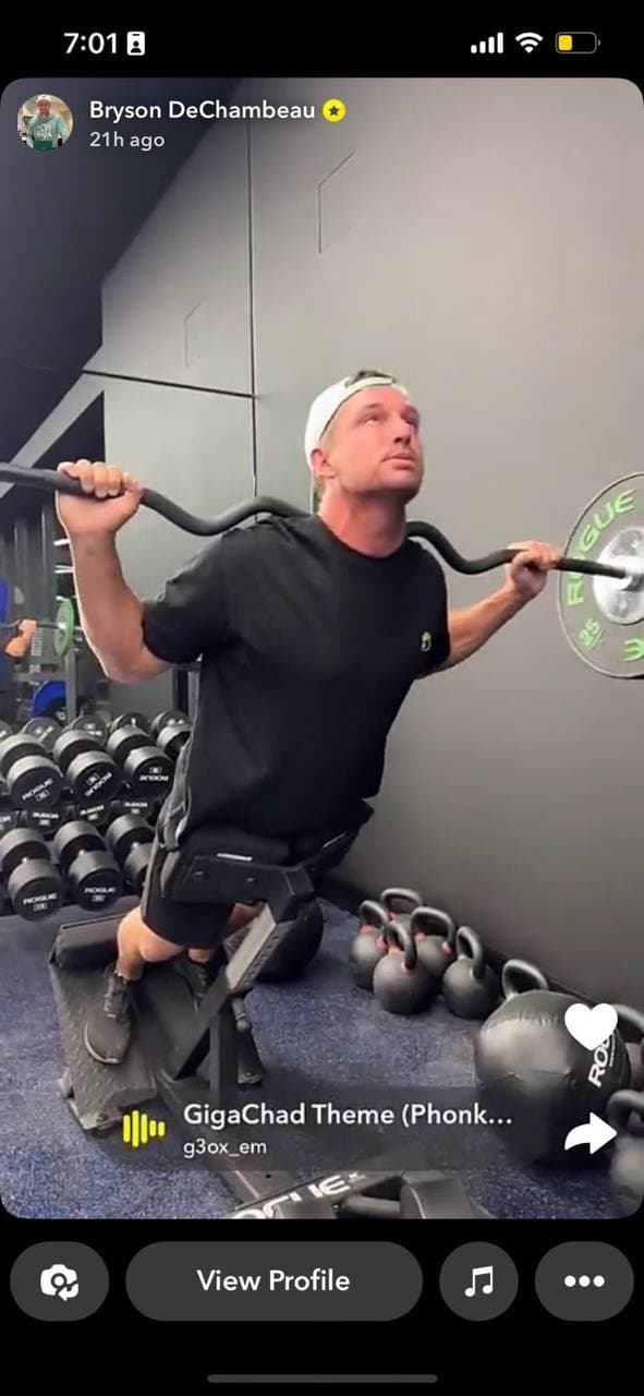 Muscular man lifting weights in a gym.