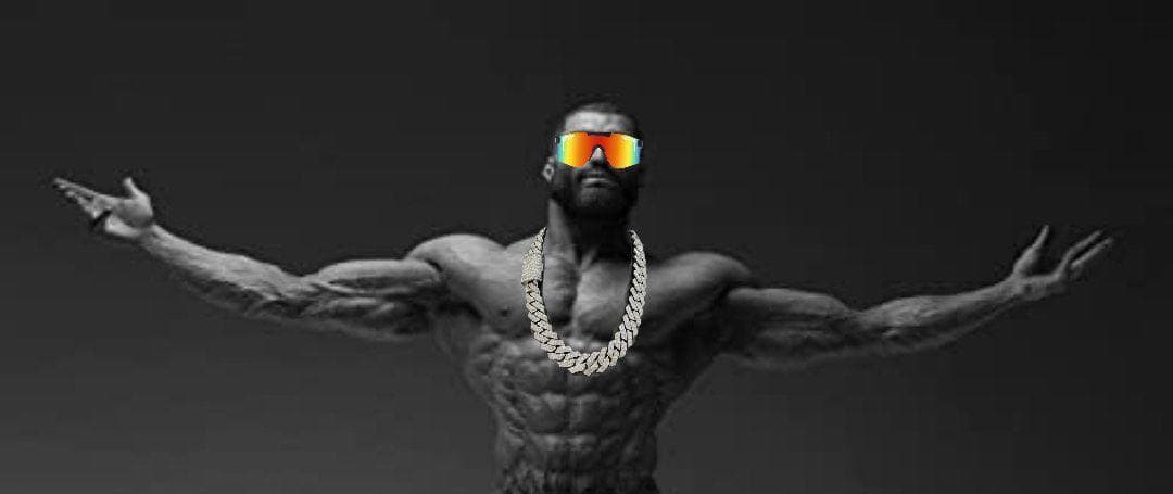 Muscular man in sunglasses and chain striking a confident pose.