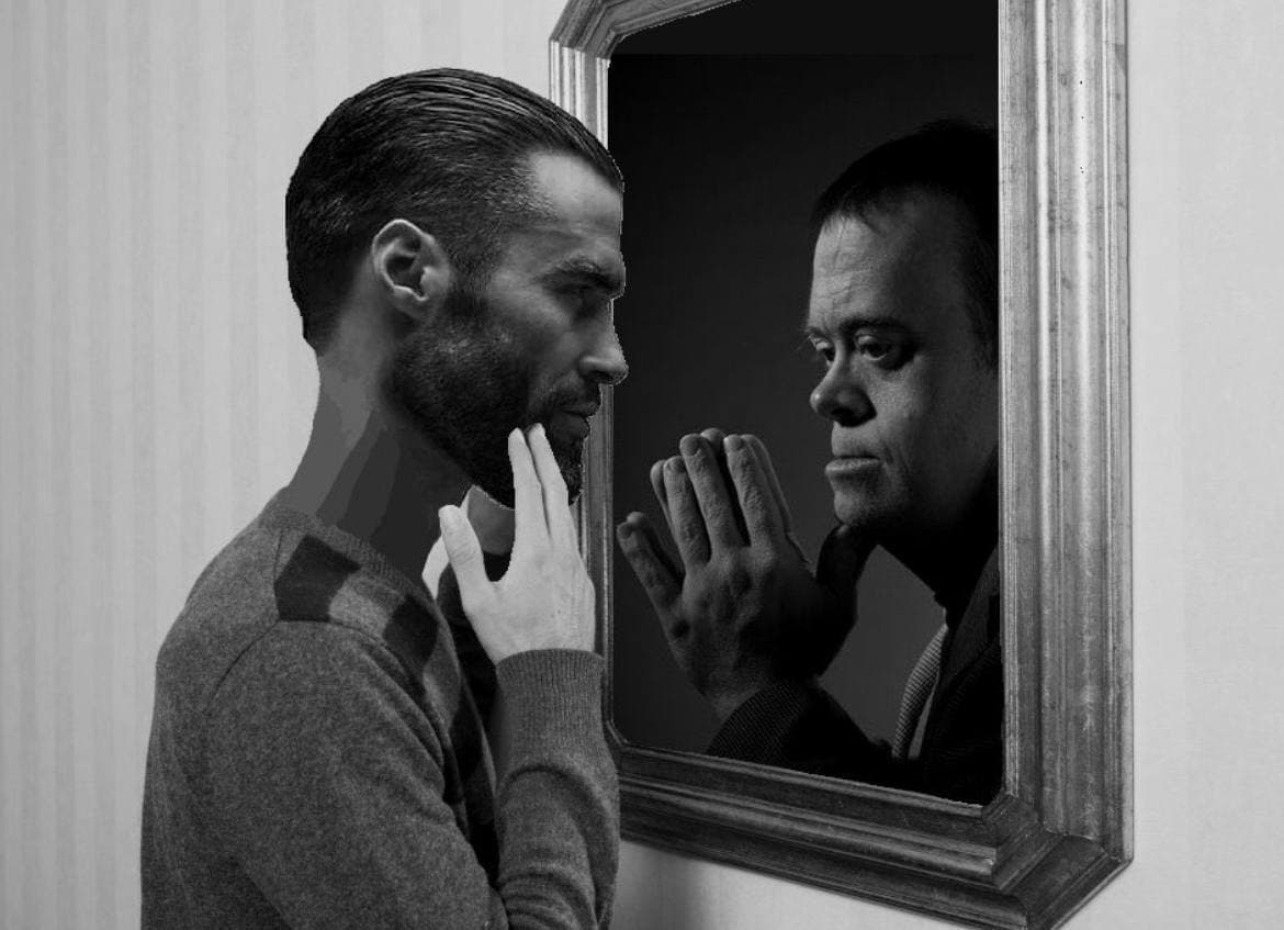 Man looks in mirror showing contrasting reflection.