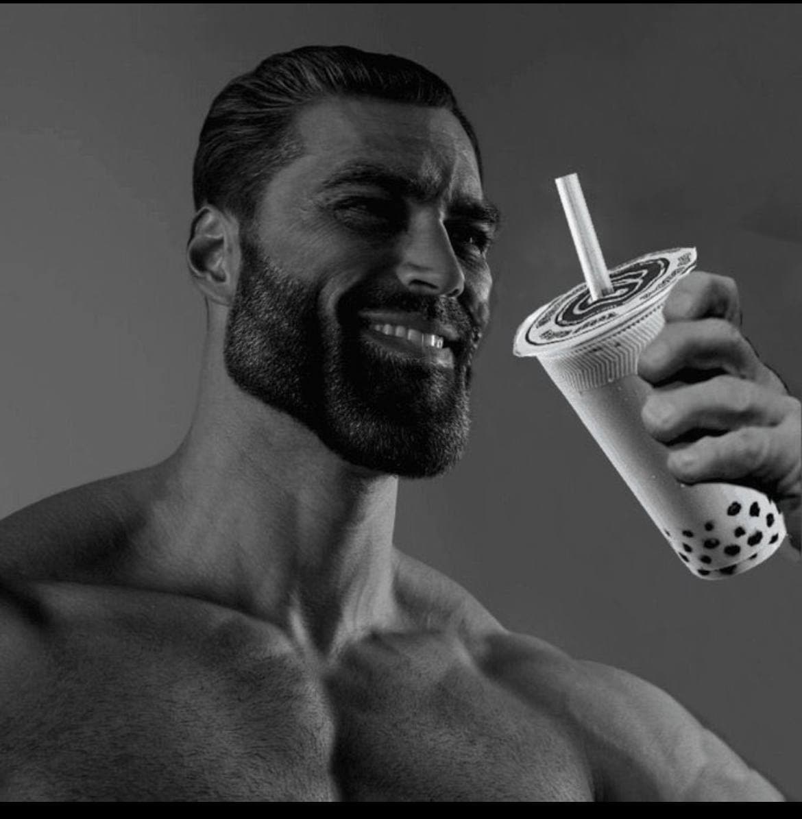 Muscular man smiling with a bubble tea in hand.
