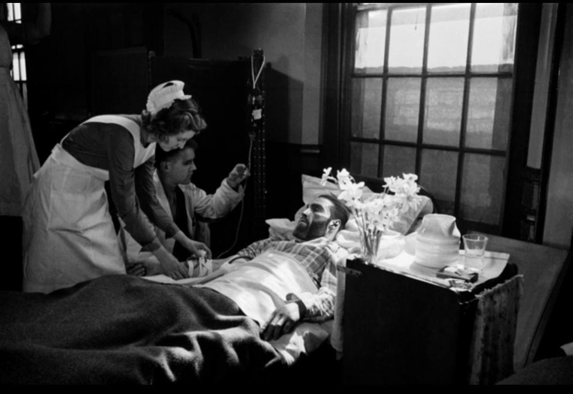 A nurse and doctor attending to a patient in a hospital.