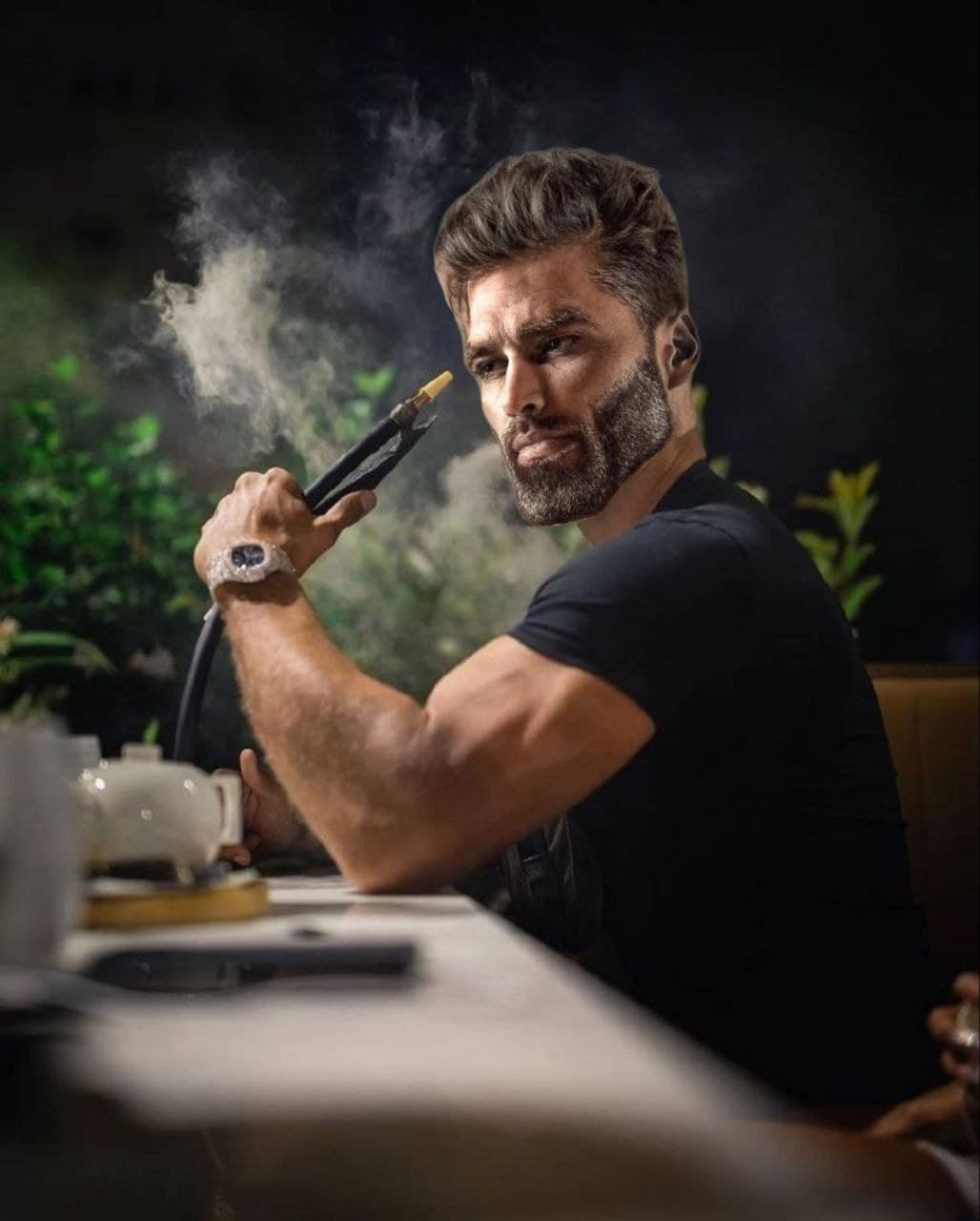 Muscular man smoking hookah with confidence.