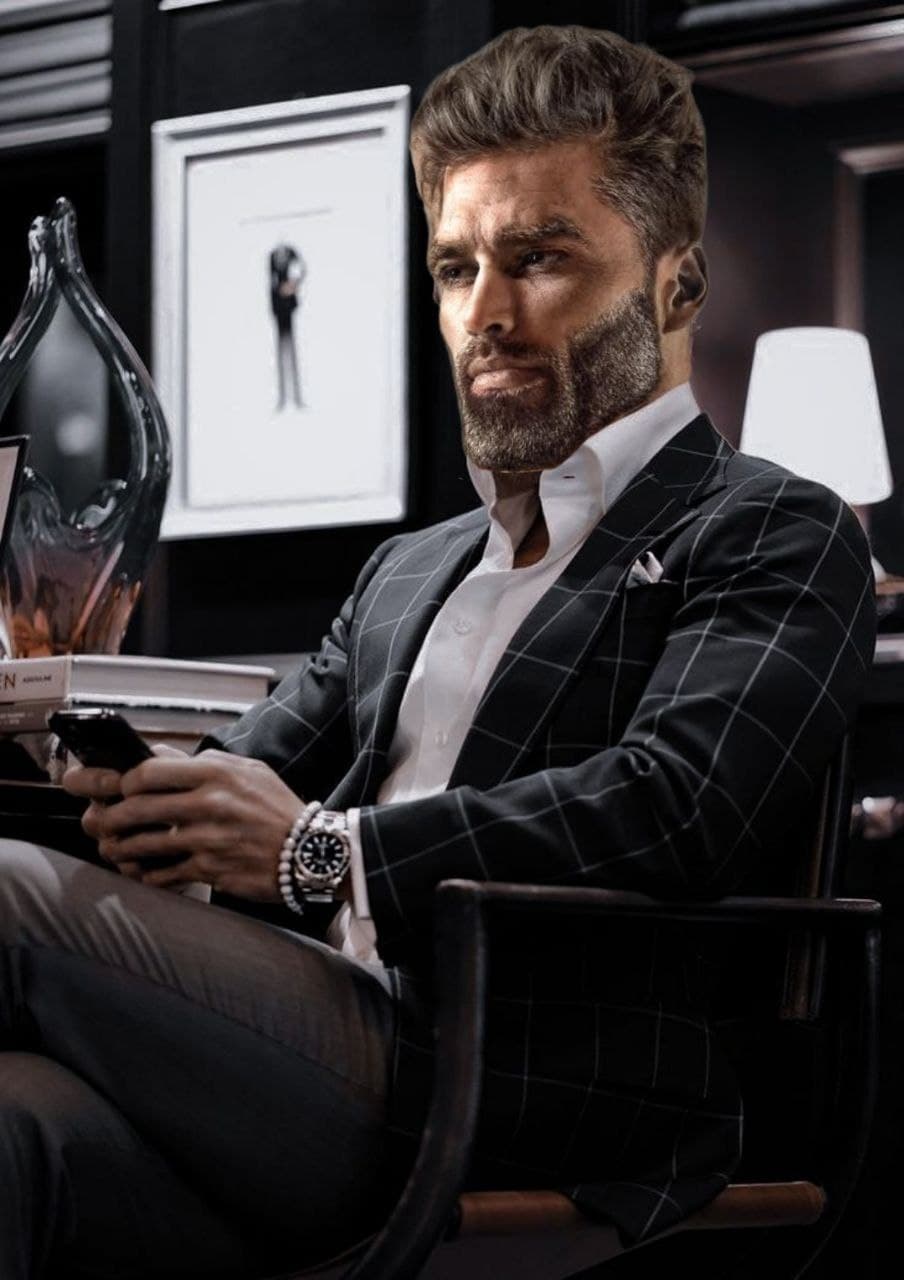 Stylish man in suit checking phone in elegant office.