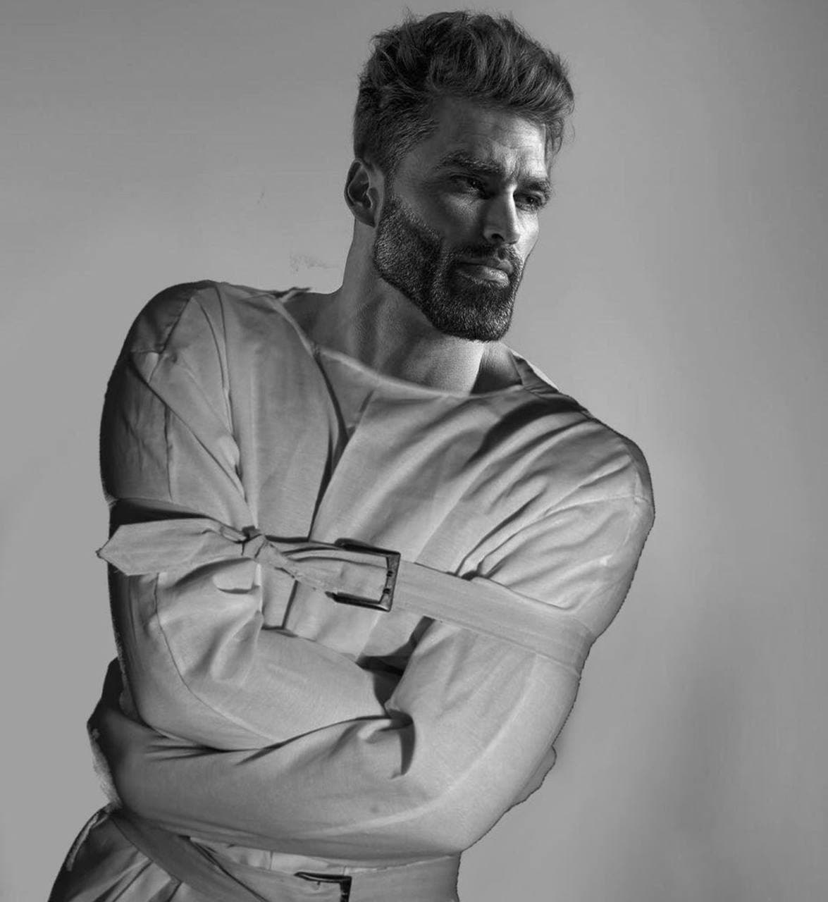 Muscular man in a straitjacket, looking thoughtful.