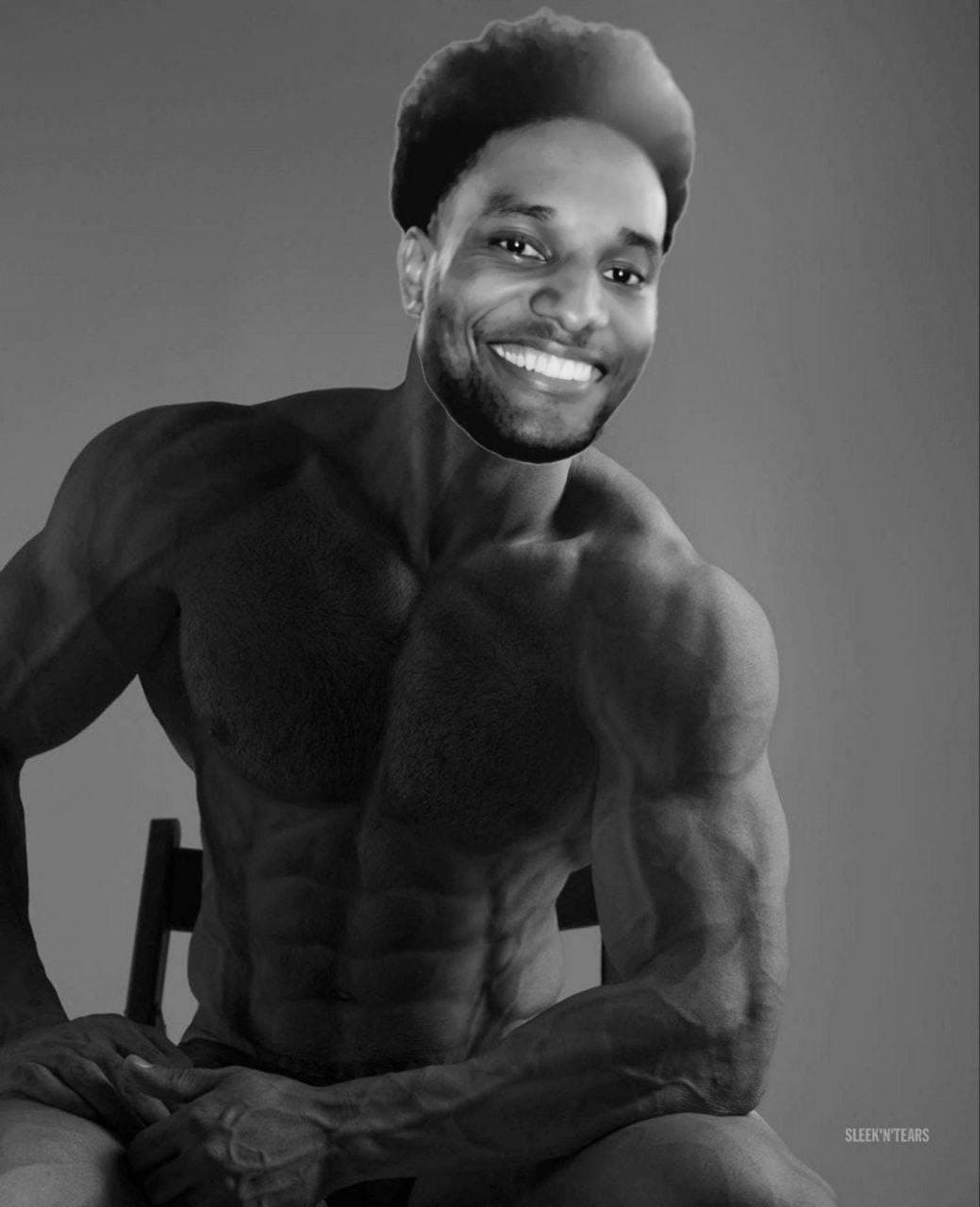 Muscular man with a smiling face seated in black and white.