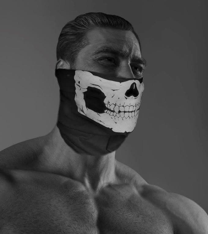 Muscular man in skull mask presenting a strong demeanor.