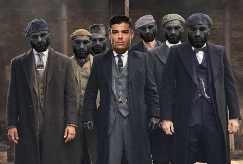 A man in a suit stands among group of serious men.