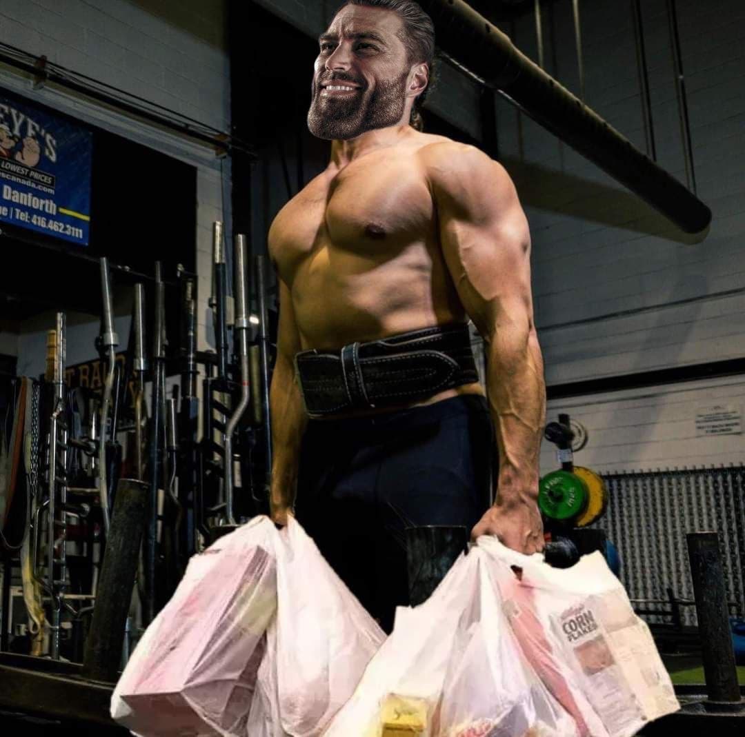 Muscular man lifting grocery bags in a gym.