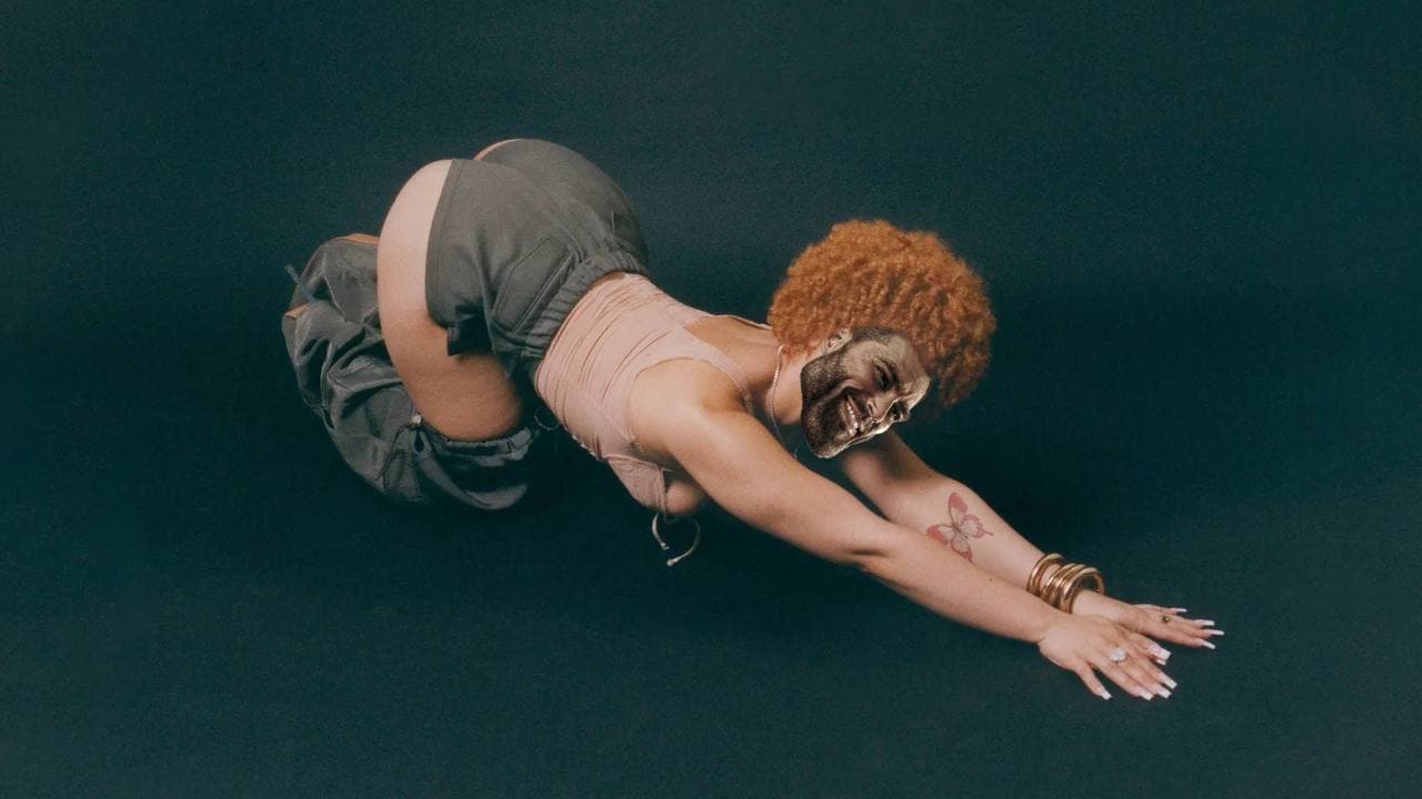 Person in a crawling pose with distorted face.