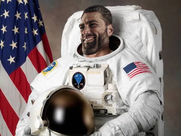 Confident astronaut smiling in a space suit with American flag.