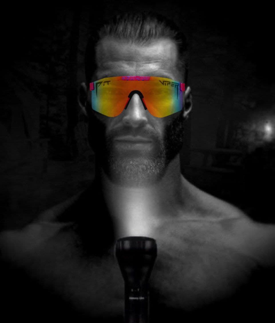 Muscular man in sunglasses with a flashlight in the dark.