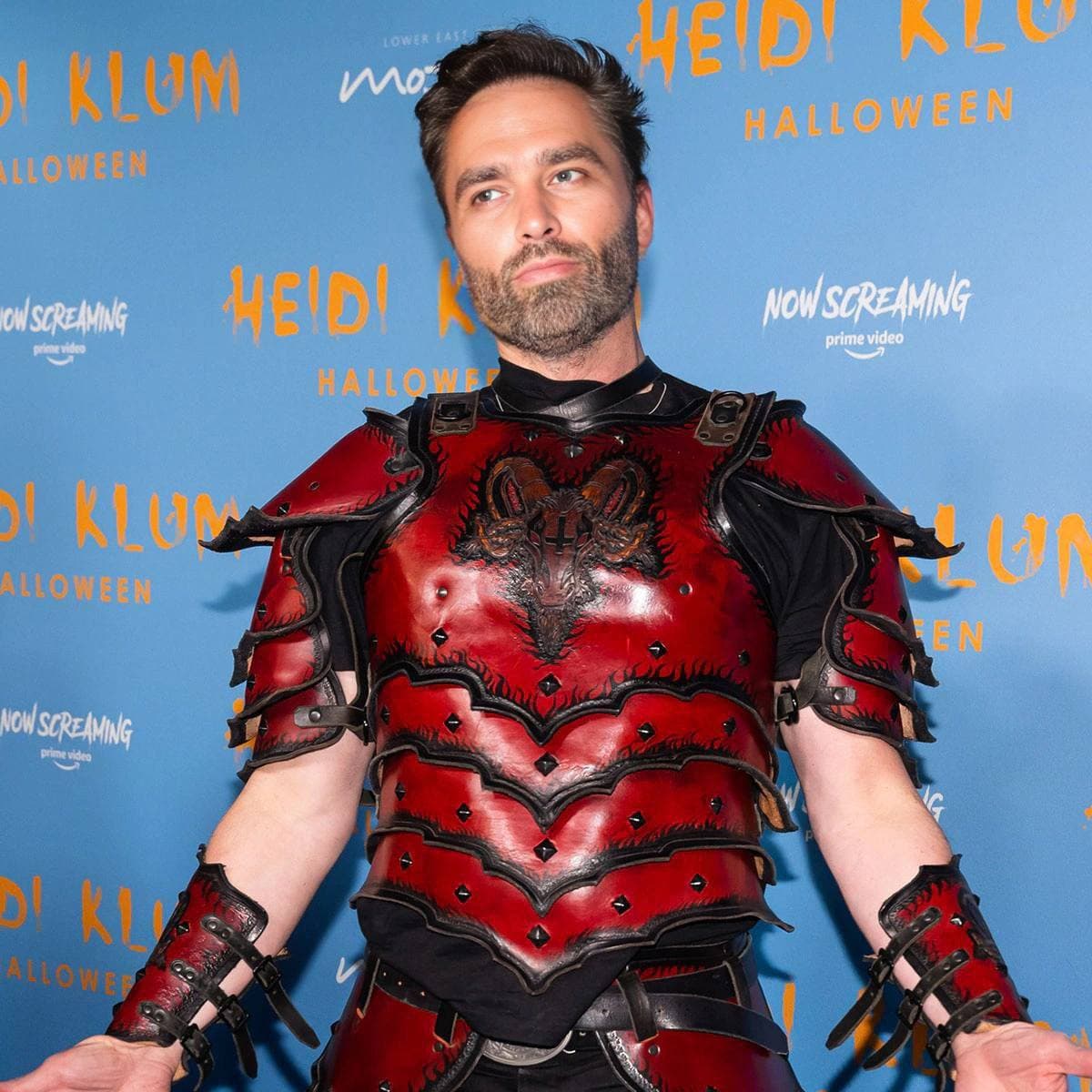 Man in red armor posing at Halloween event.