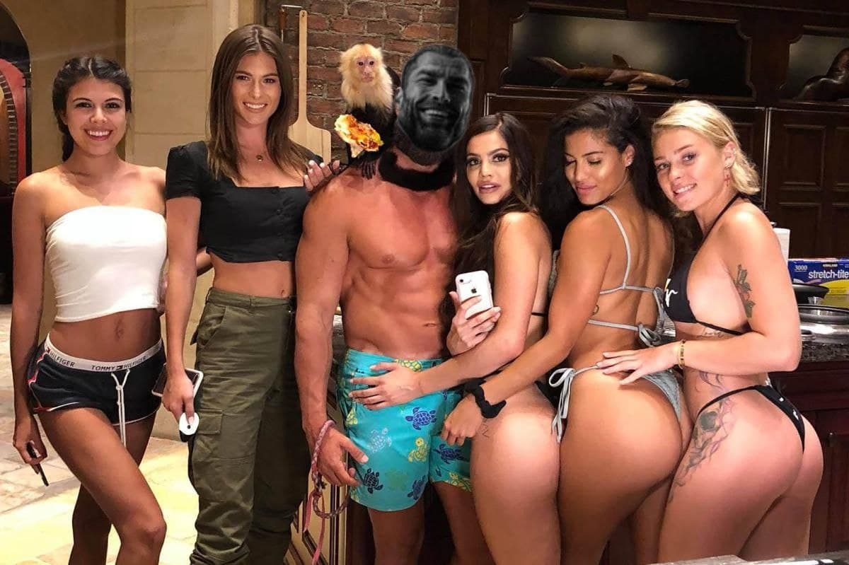 Muscular man with monkey posing with five women in kitchen.