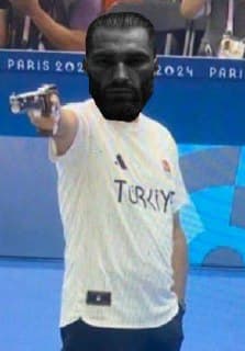 Person in sports shirt points a gun confidently.