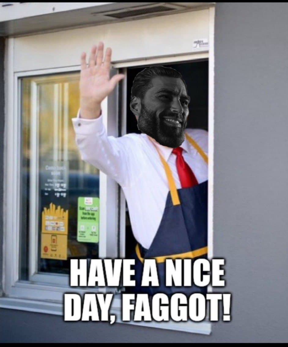 A man waves from a drive-thru with a bold message.
