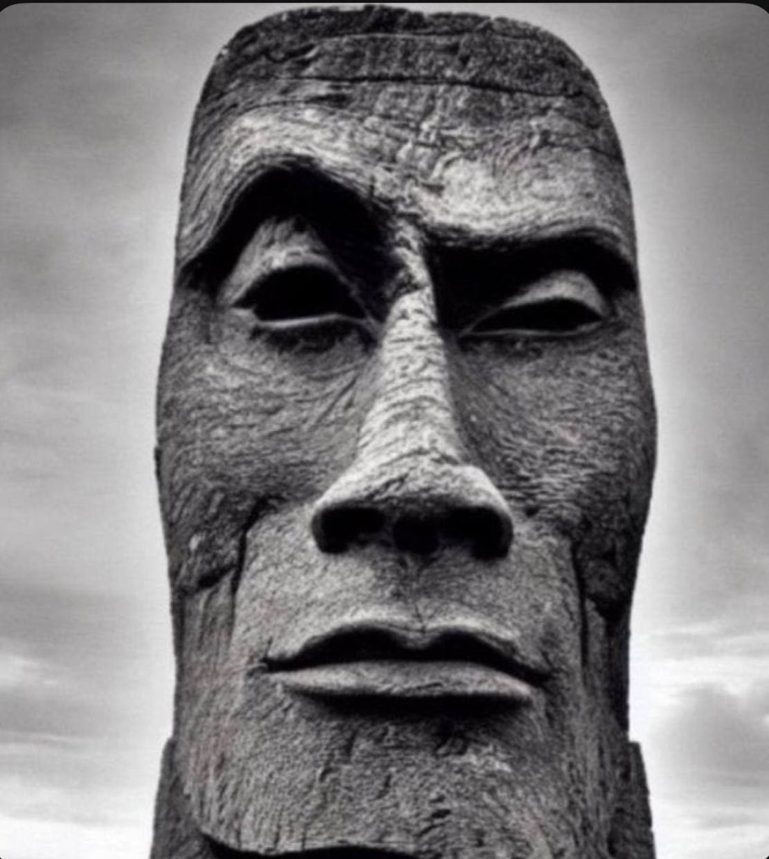 A massive stone statue with a serious facial expression.