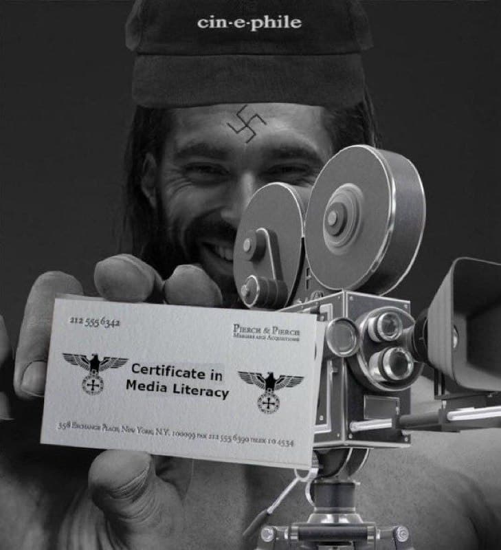 Man proudly shows media literacy certificate beside film camera.