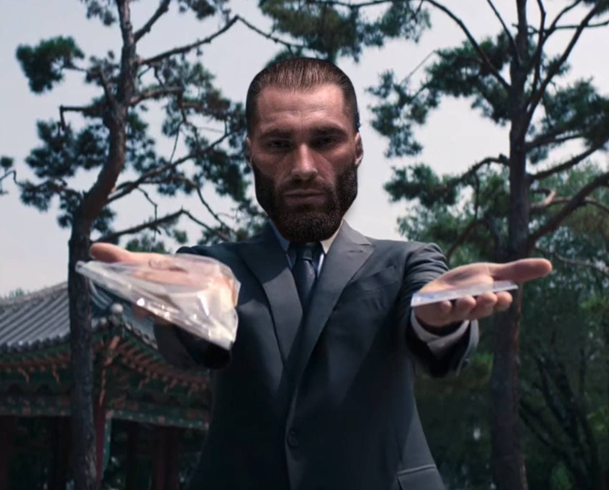 Man in suit offering a package with intense expression.