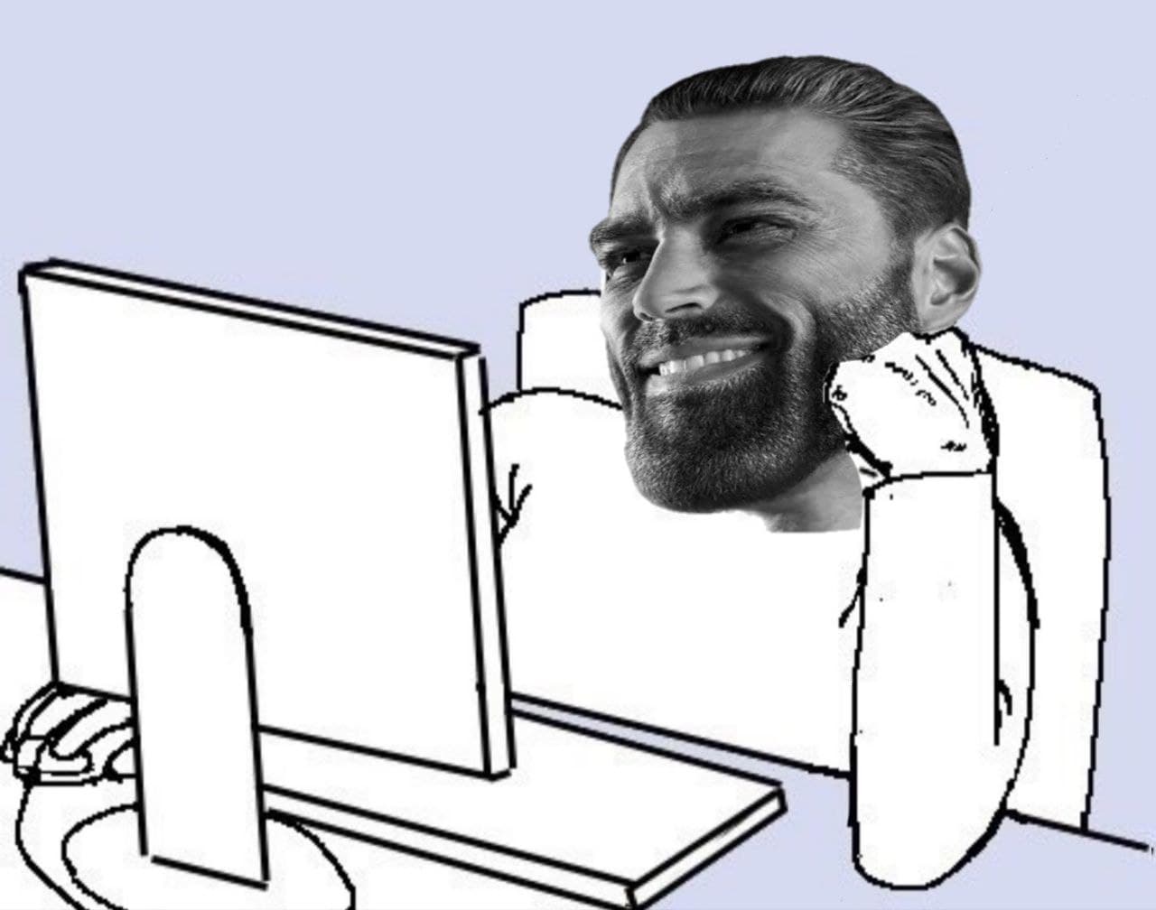 Muscular man with beard smiling while using a computer.