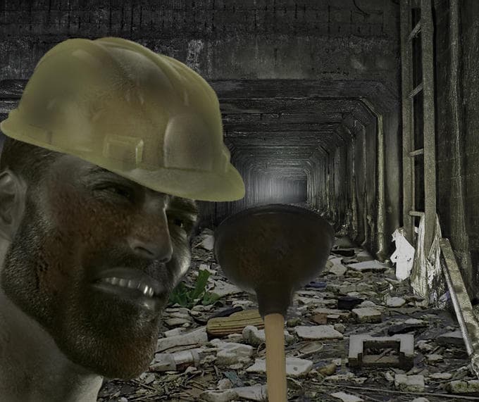 Man in hard hat holding plunger in a dark tunnel.