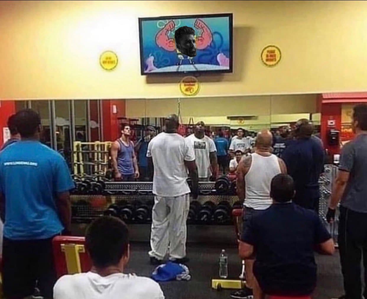 A group of men admiring GigaChad on a gym TV.