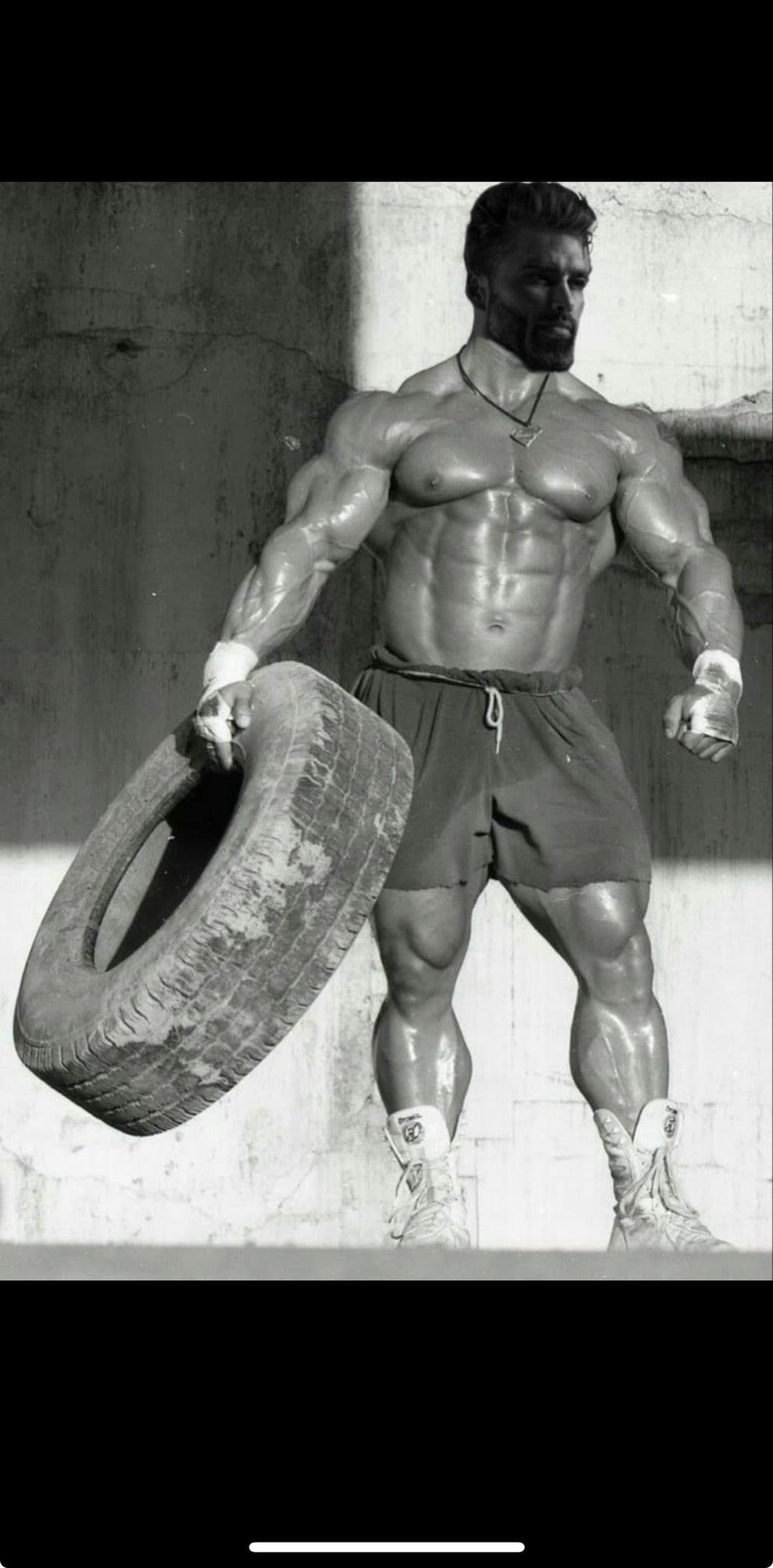 Muscular man lifting a tire in a dramatic pose.