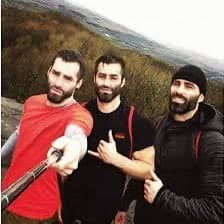 Three muscular men taking a selfie on a mountain top.