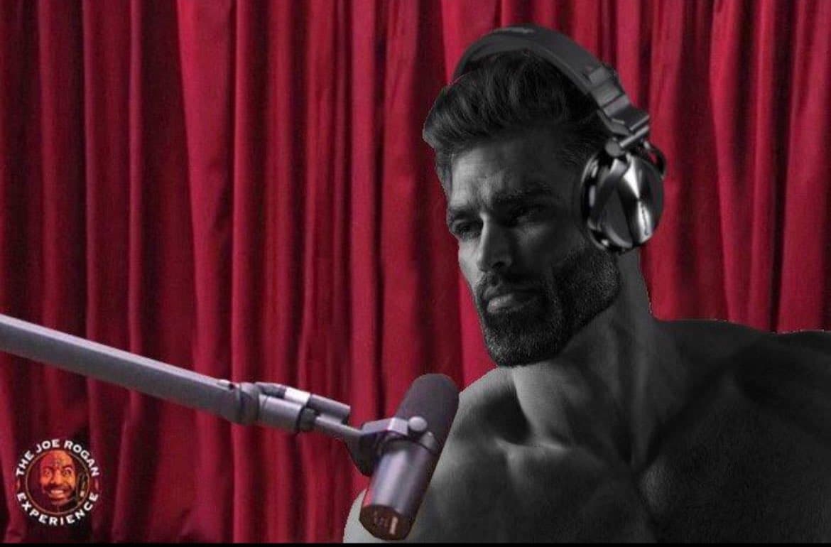 Muscular man with headphones at a microphone.