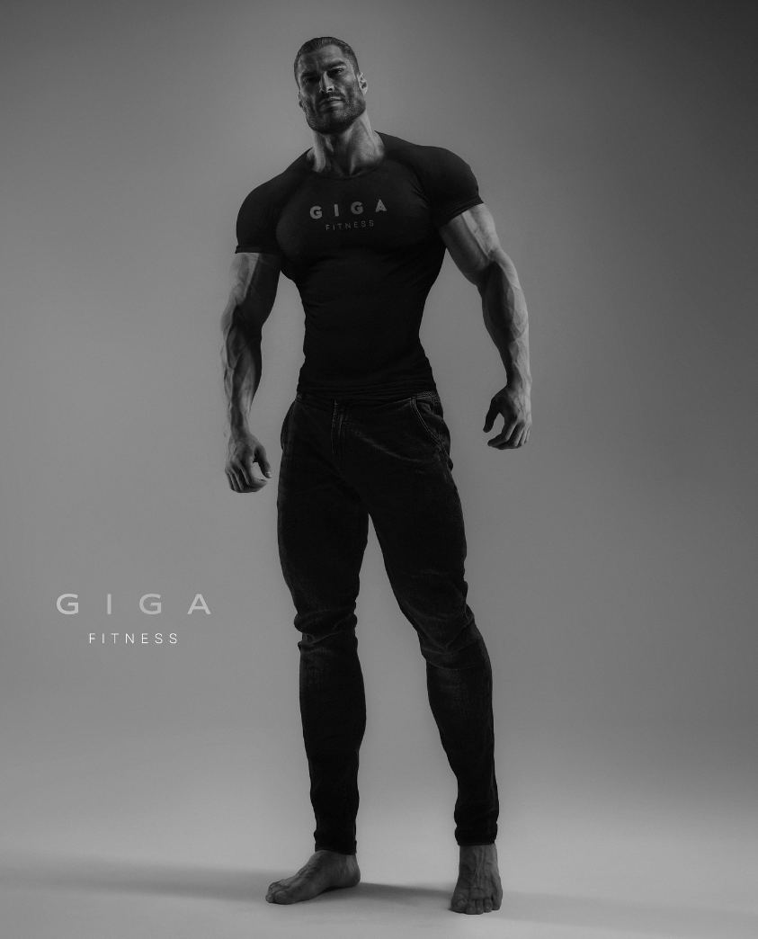 Muscular man in black shirt poses confidently for fitness brand.