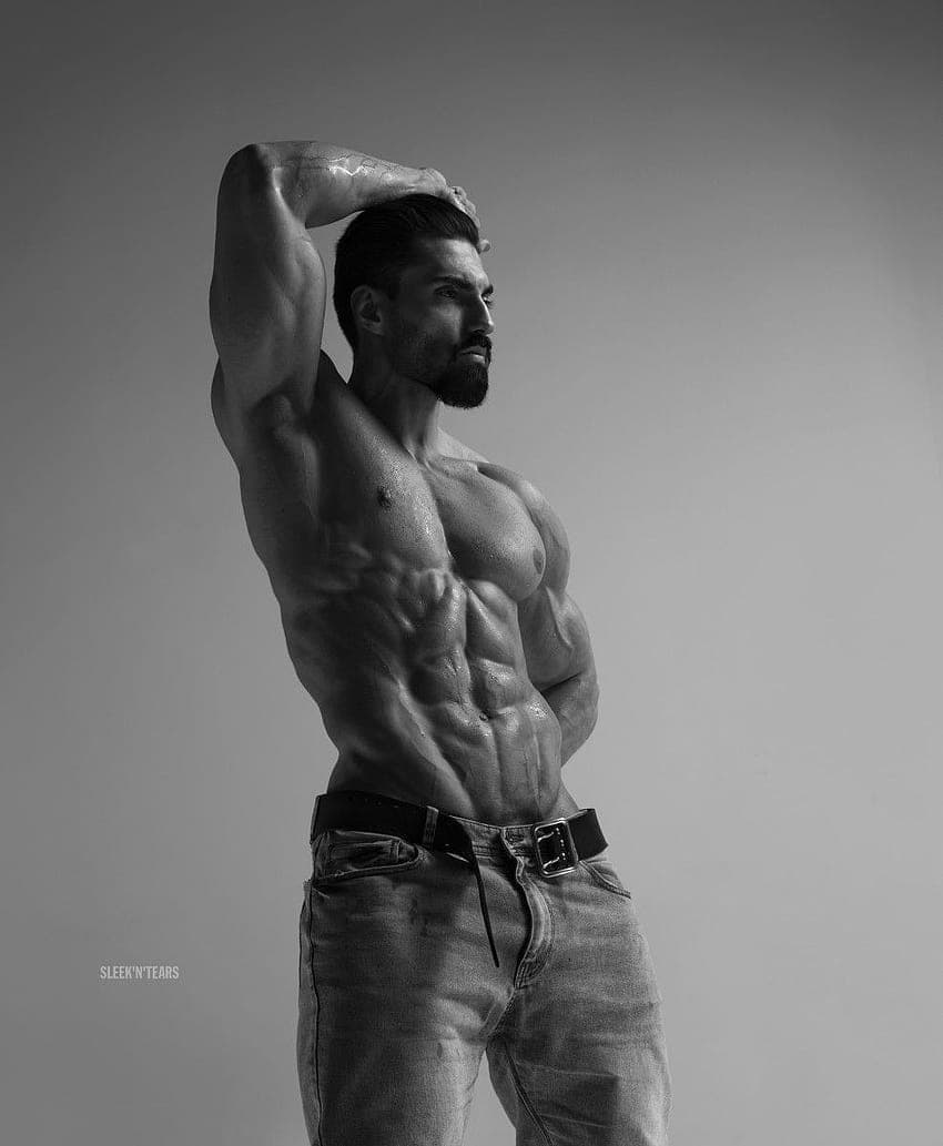 Muscular man displaying a confident pose in black and white.