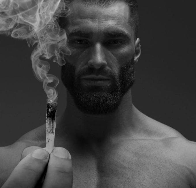 A muscular man holding a cigarette with smoke rising.