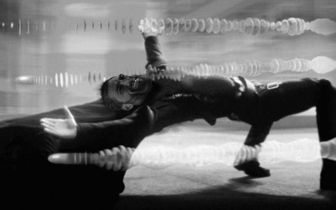 Muscular man leaning back with sound waves around him.