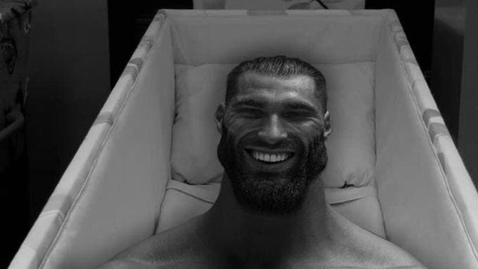 Smiling muscular man in a coffin with a confident expression.