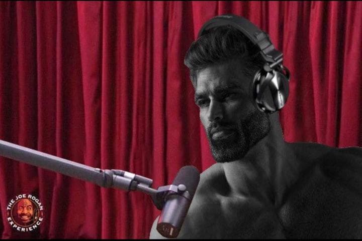 Buff man in headphones contemplating into a microphone.