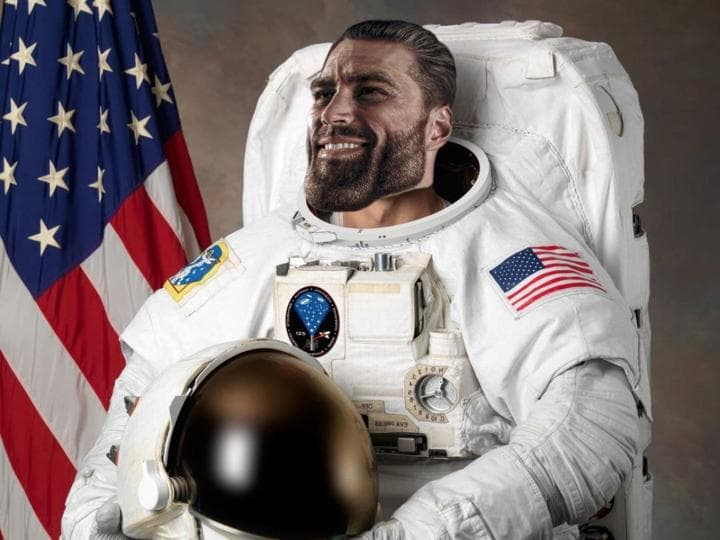 Muscular astronaut poses with a confident grin beside the American flag.