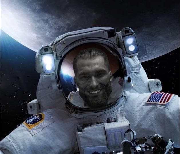 Astronaut in space with a smiling, confident face.