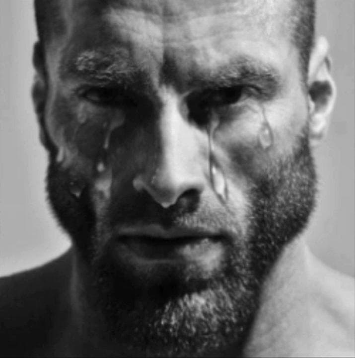 Muscular man with tears streaming down his face.