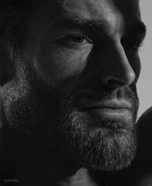 Close-up of a muscular man's face in high contrast lighting.