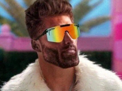 Confident man in sunglasses and fur coat poses stylishly.