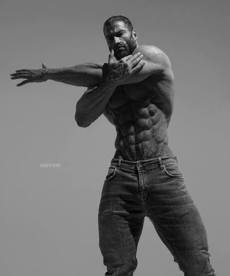 Muscular man flexing in a black and white photo.