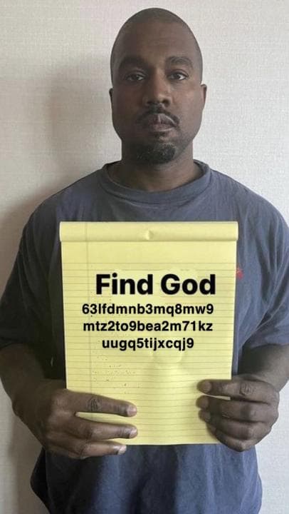 Man holding a notepad that says 'Find God'.